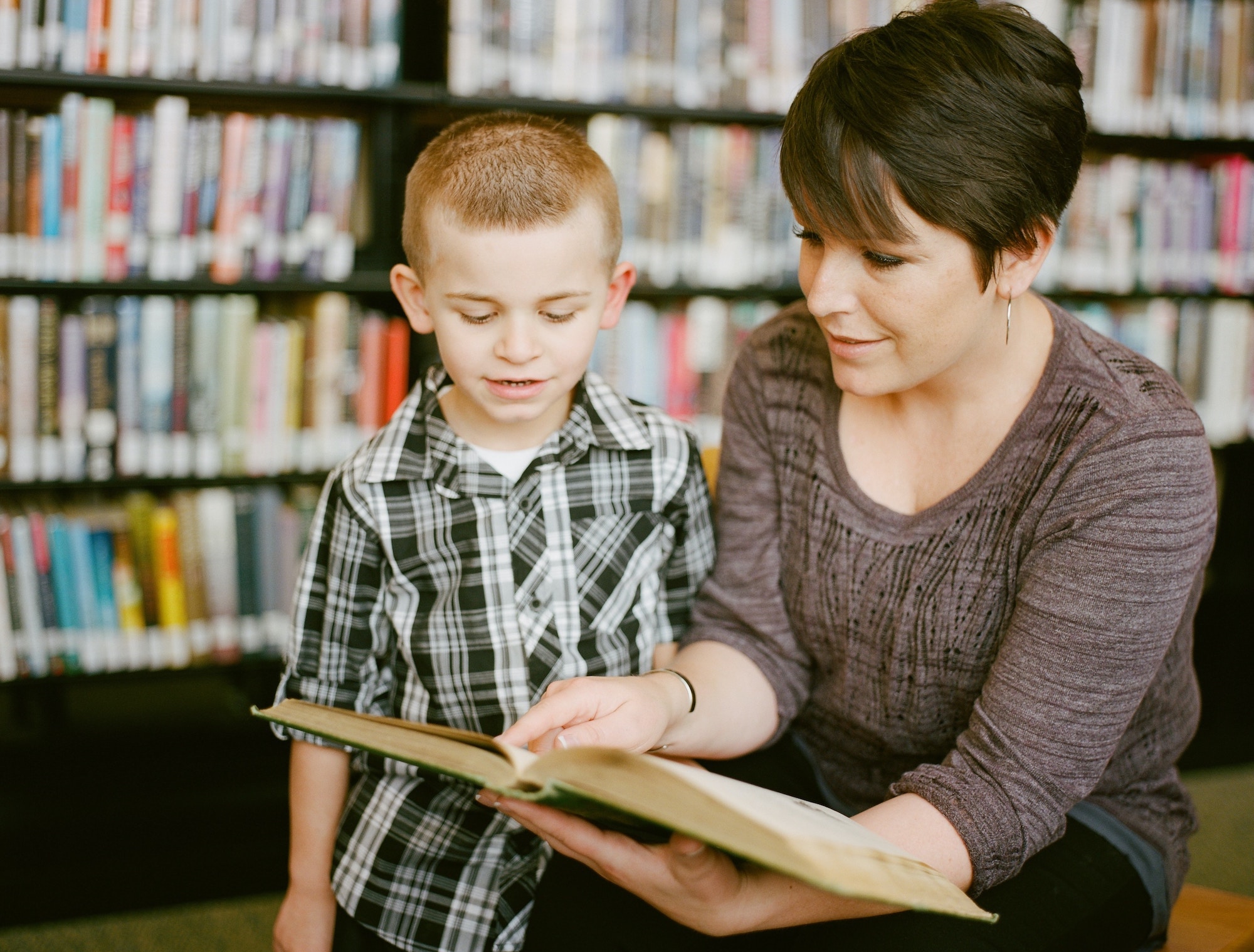 A woman reading a book to a child