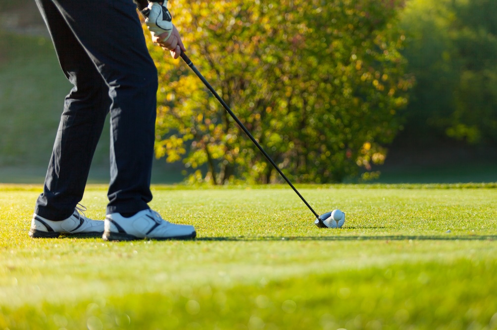 man takes swing on golf course